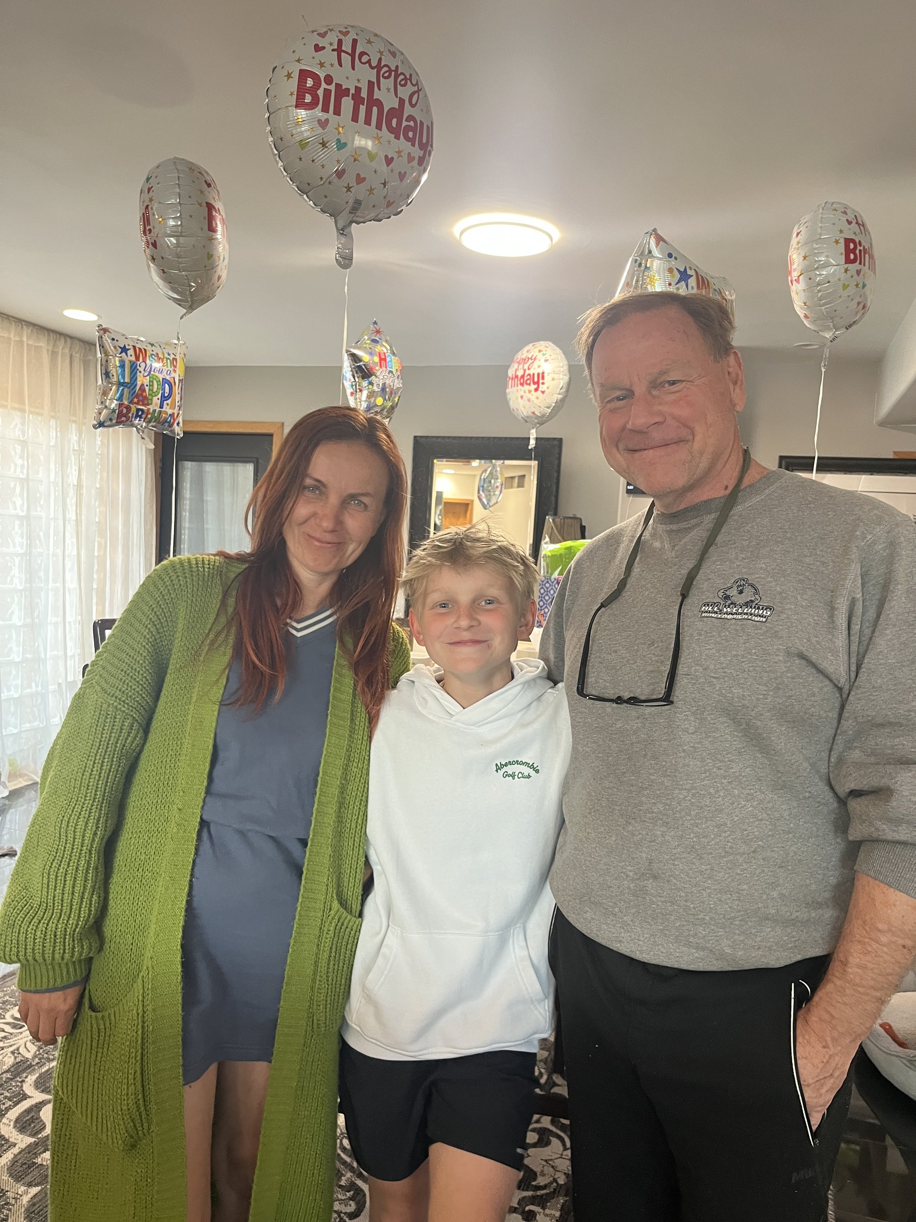 Chris with family at a birthday celebration, wearing the All Welding & Fabrication sweatshirt